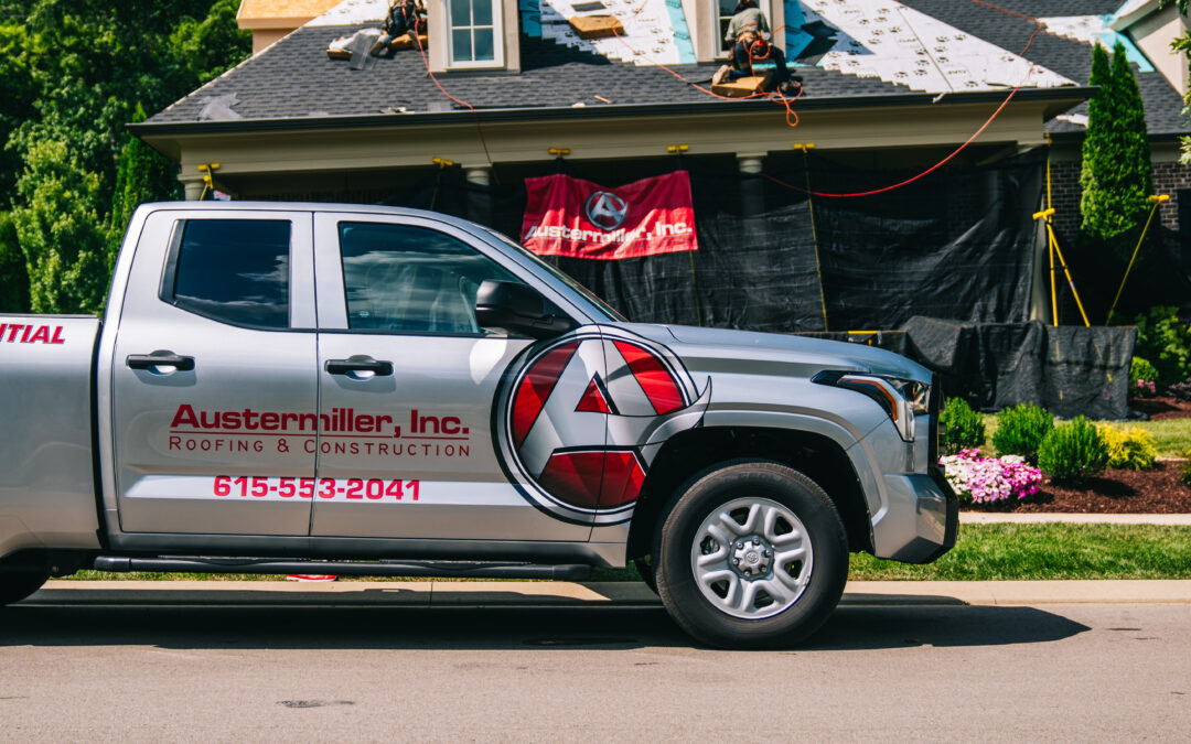 Close up of Austermiller company truck in front of home, which is undergoing a roof replacement/repair