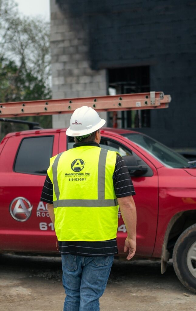 A Nashville commercial roofing professional installing a roofing system at the top of a commercial building in Nashville, TN