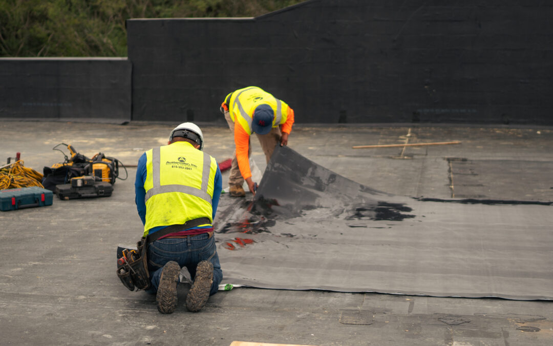 Two roofers replacing a commerical roof.