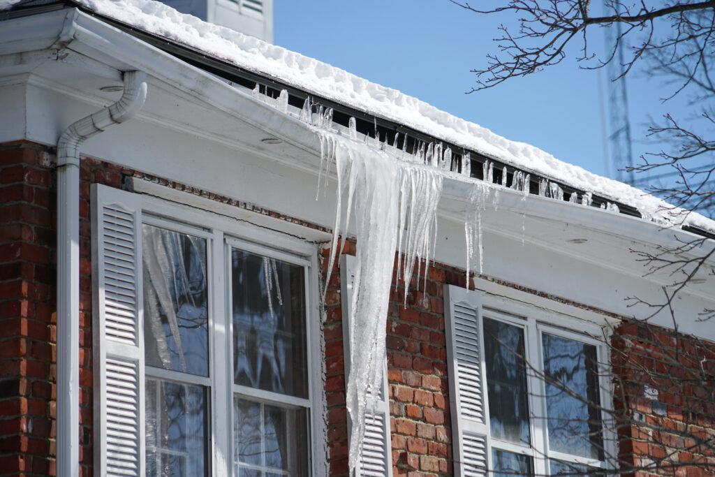 House with snow/ice melting off gutter.